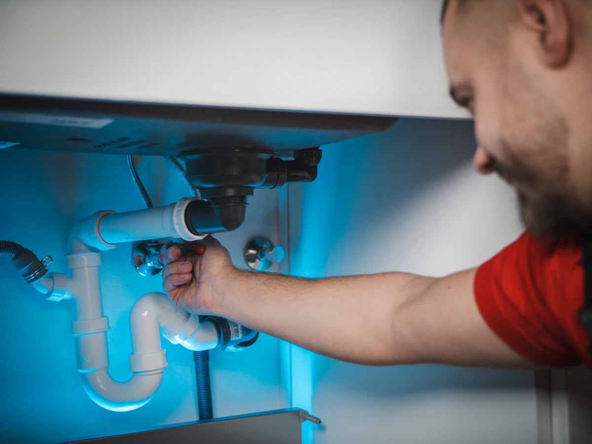 Technician repairing RO water purifier under sink in Munirka
